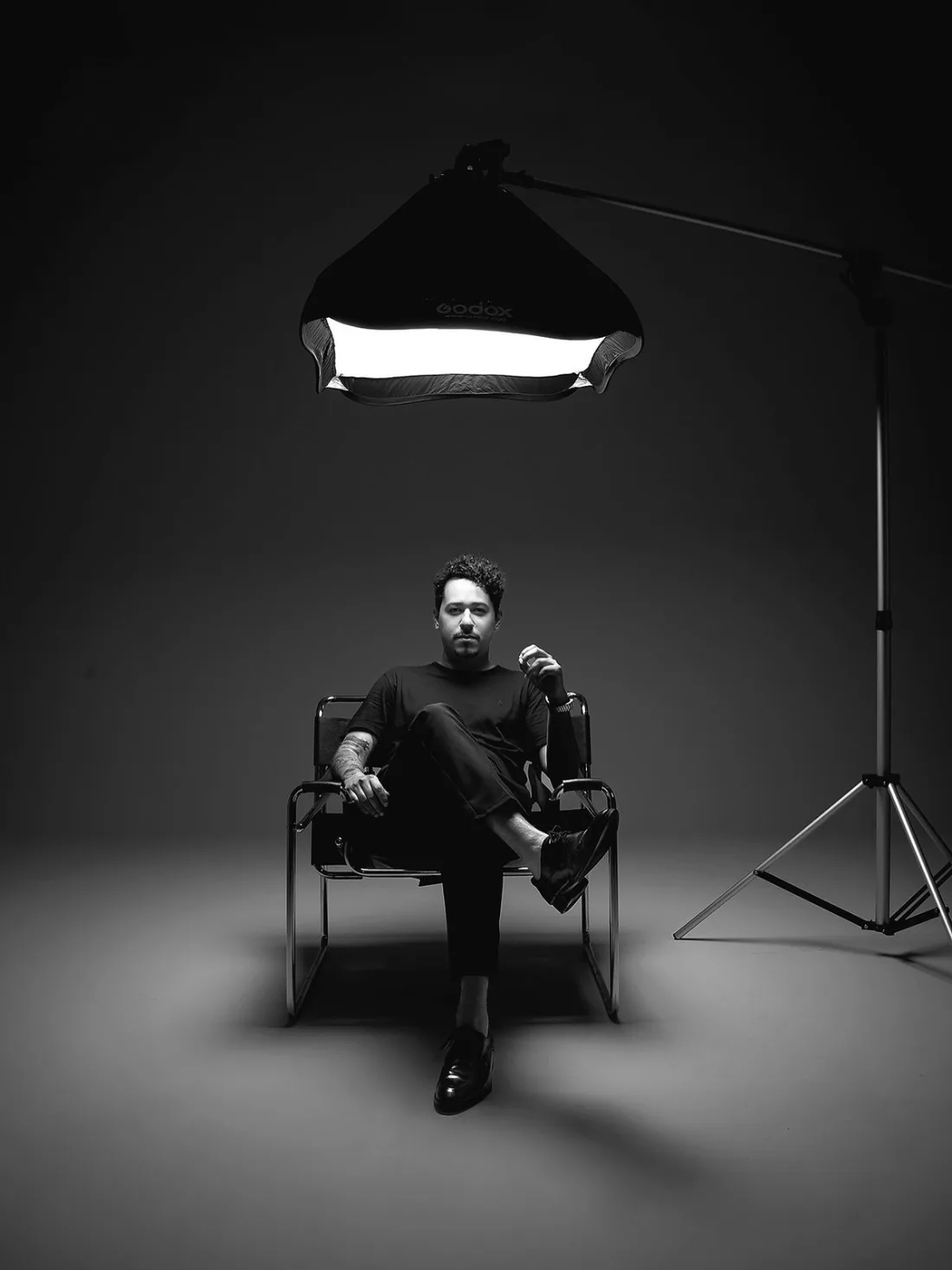 Set video in studio con una persona seduta sotto la luce: produzione video
